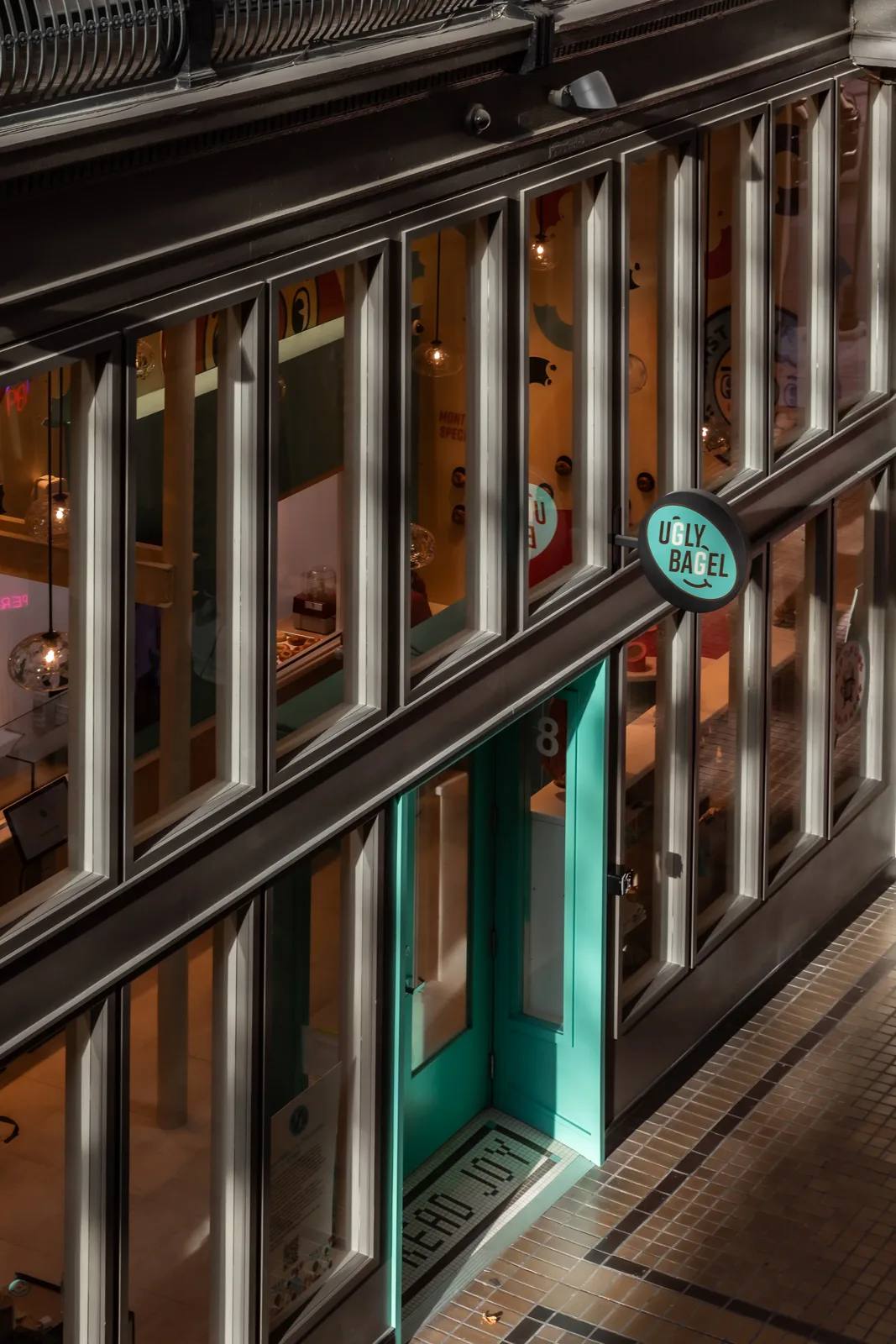 Ugly Bagel storefront window in the evening