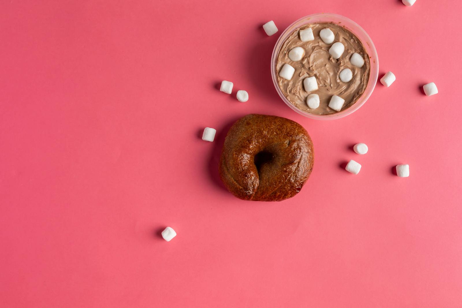 Assorted Ugly Bagel flavors on a pink backdrop