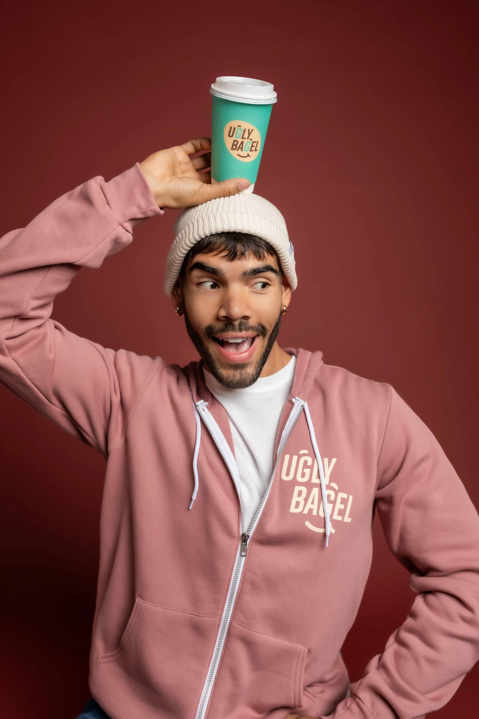 Ugly Bagel guest playfully balancing a hot coffee